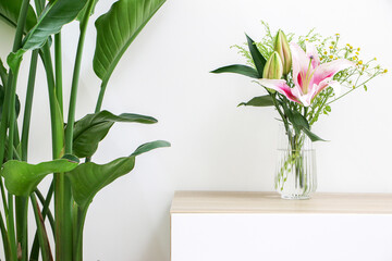 Vibrant plants and flowers decorating home interior, bouquet of flowers (pink lilies and daisies)...