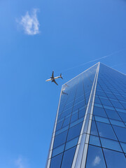 Obraz premium Airplane and office building with blue sky