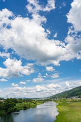 橋の上から見る青空と川沿いの町並み