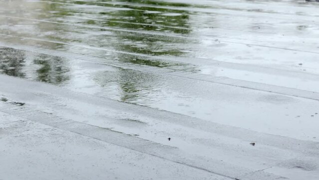 Raindrops knock on the roof, heavy rain, downpour. The flat roof of the building is covered with a waterproof material that protects from rain. Ruberoid, rolled roofing and waterproofing material.