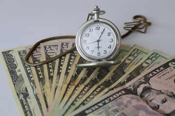 Dollar and old clock. Selective Focus. 