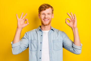 Photo portrait of nice young man show double okey symbol approve good job dressed trendy denim outfit isolated on yellow color background