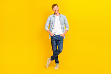 Naklejka premium Photo of cool cheerful guy dressed denim shirt walking smiling isolated yellow color background