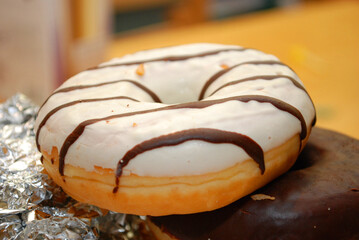 Ein Donut mit Zuckerglasur und Schokostreifen.