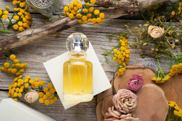  perfume bottles around yellow flowers and ingridients  at  wooden old style background . flat lay....