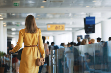 Woman walking in airport terminal. Back view.