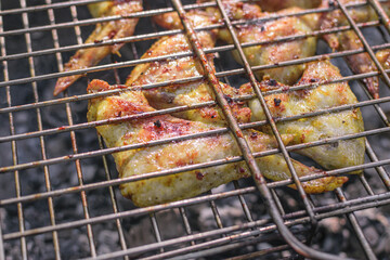 Delicious chicken wings grilled on burning coals
