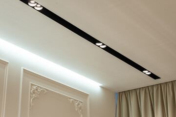 Suspended ceiling with halogen spots lamps and drywall construction in empty room in apartment or...
