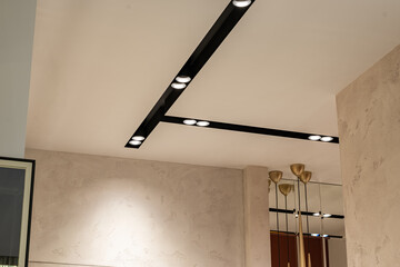 Suspended ceiling with halogen spots lamps and drywall construction in empty room in apartment or...