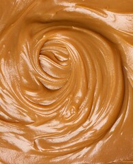 Vertical closeup shot of a smooth creamy brown peanut butter surface