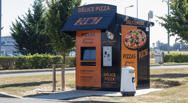 D&eacute;lice Pizza install&eacute; dans le parking d'une zone d'activit&eacute;, Distributeur de pizza, automate &agrave; pizza, robot pizzaiolo.