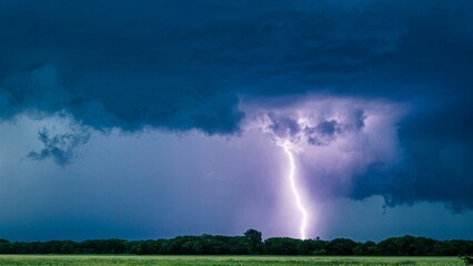 Beautiful shot of purple lightning striking on a field