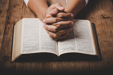 Close up of christian woman hand on holy bible are pray and worship for thank god in church with black background, concept for faith, spirituality and religion - obrazy, fototapety, plakaty