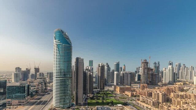 Panorama showing Dubai's business bay and downtown towers aerial morning timelapse. Rooftop view of some skyscrapers and new buildings under construction with thaditional houses of old town district