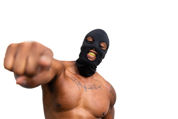 Shirtless tattooed African American man with black mask, gold fangs, and pointing finger 