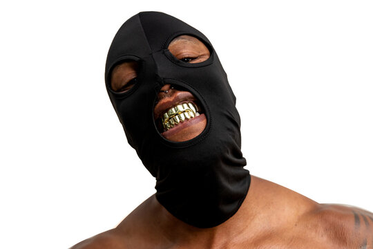 Shirtless tattooed African American man with black mask and gold fangs