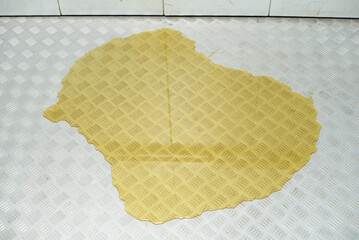 Large yellow puddle of liquid or urine on the floor in the elevator