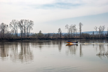 fishing on the river bank in the morning. spring fishing in nature. motor boat with a fisherman floats on the river