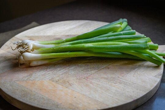 Green onions on wooden board
