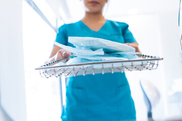 Crop anonymous dentist sterilizing tools in autoclave