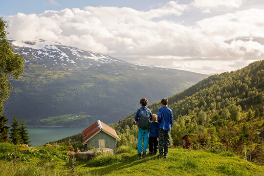 People, adult with kids and pet dog, hiking mount Hoven, enjoying the splendid view over Nordfjord from Loen skylift