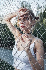 A young girl behind a mesh fence.