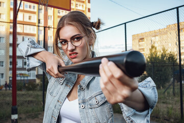 A girl with a baseball bat in her hands.