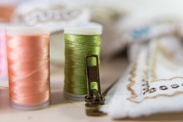 Fototapeta na wymiar close-up close-up, threads behind, dressmaker, atelier, seamstress, sewing clothes, embroidering a fabric, needle and thread, selective focus