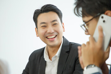 Fototapeta premium Portrait of a smiling businessman. Positive young office worker smiling with co-worker in foreground.