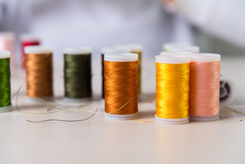 yellow and orange, close-ups of colored threads, dressmaker, atelier, seamstress, sewing clothes, embroidering a fabric, needle and thread, selective focus