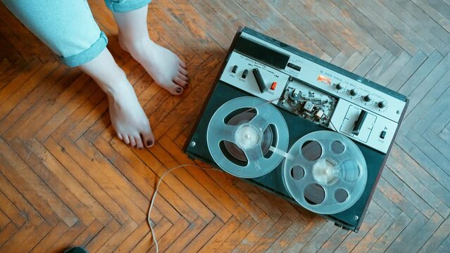 Launching an old reel-to-reel tape recorder close-up against the background.