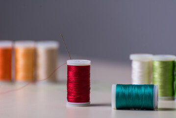 close up of red thread with threads behind, dressmaker, workshop, sewing, sewing clothes, fabric embroidery, selective focus