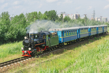 Naklejka premium Passenger steam train of Children's railway moves to the station. Saint Petersburg.