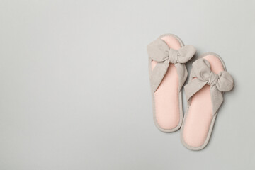 Soft pink slippers on color background, top view