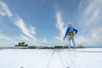 A Roofer using electric drill nail gun installing PU foam roof sheet at under construction. Safety...