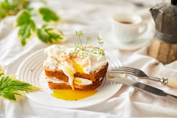 Breakfast on white bed sheets, good morning, toast with poached eggs, coffee, flowers, Hotel room early morning, honeymoon