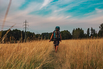 Hiker with the backpack on the field