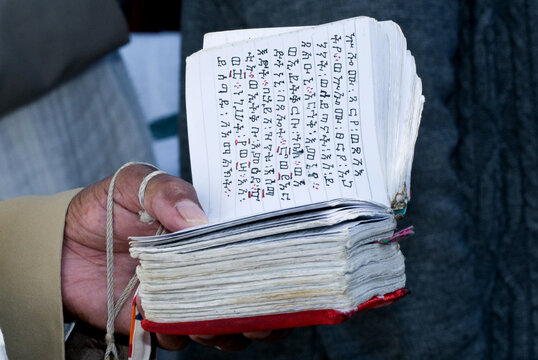 An Ethiopian man holds a traditional Jewish prayer book written in the Amharic language.