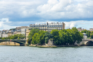 Square Barye and Ile Saint-Louis island seen from a Bateau Mouche tour boat cruising on the Seine...