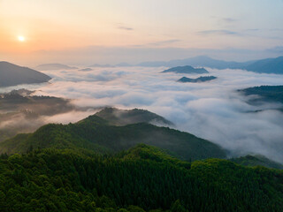 Sunrise over sea of clouds in mountains around historic Takeda Castle