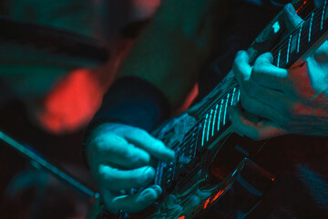 The guitarist plays on guitar. Hands of a Guitar player playing the guitar. Selective focus. Soft focus