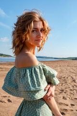 A beautiful girl walks along the sandy beach.