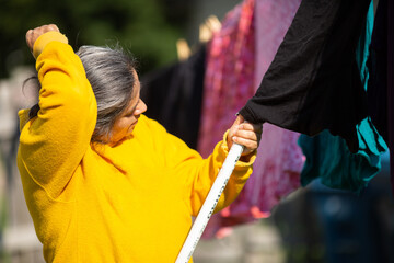 Woman Using Clothe Lines To Dry Clothes In an Energy Efficient Way