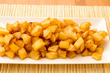 Fried diced potatoes on a white plate.