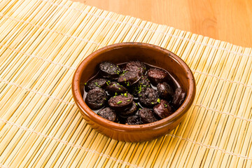 Chorizo ​​in wine, tapas and typical Spanish food in a clay pot.