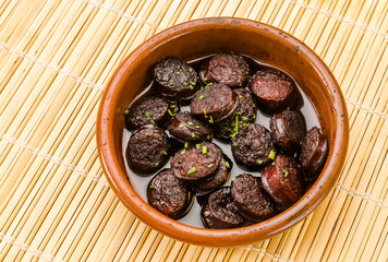 Chorizo ​​in wine, tapas and typical Spanish food in a clay pot.