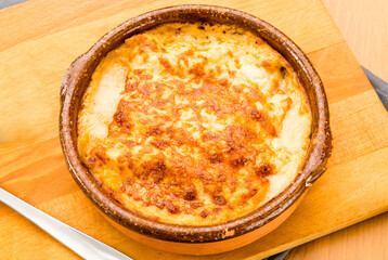 Meat lasagna au gratin in a clay pot.