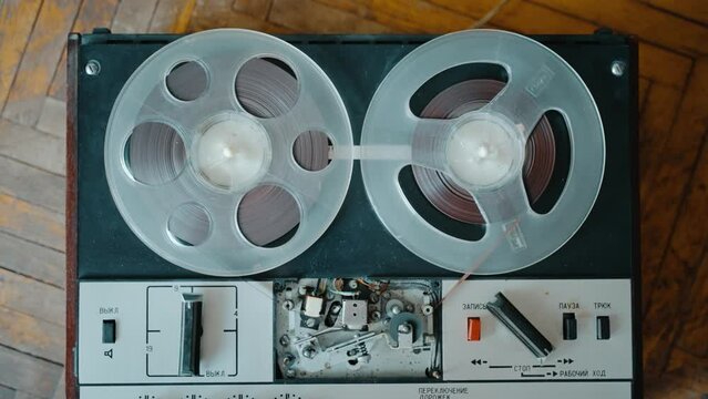 The girl turns on the old reel-to-reel tape recorder and playback is in progress