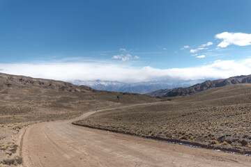dirt road between mountains in sunny day
