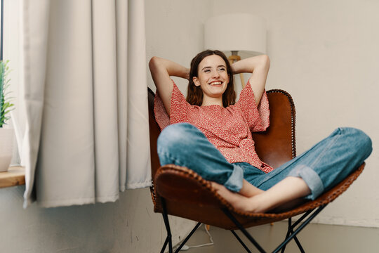 Young woman relaxing in leather armchair